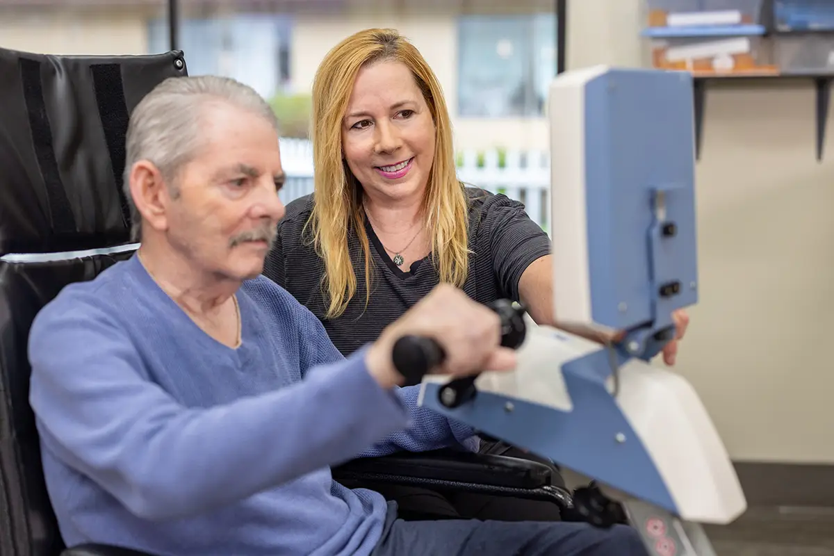 A physical therapist helping an elderly man at Oak River