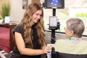 A nurse helping an elderly woman at Oak River