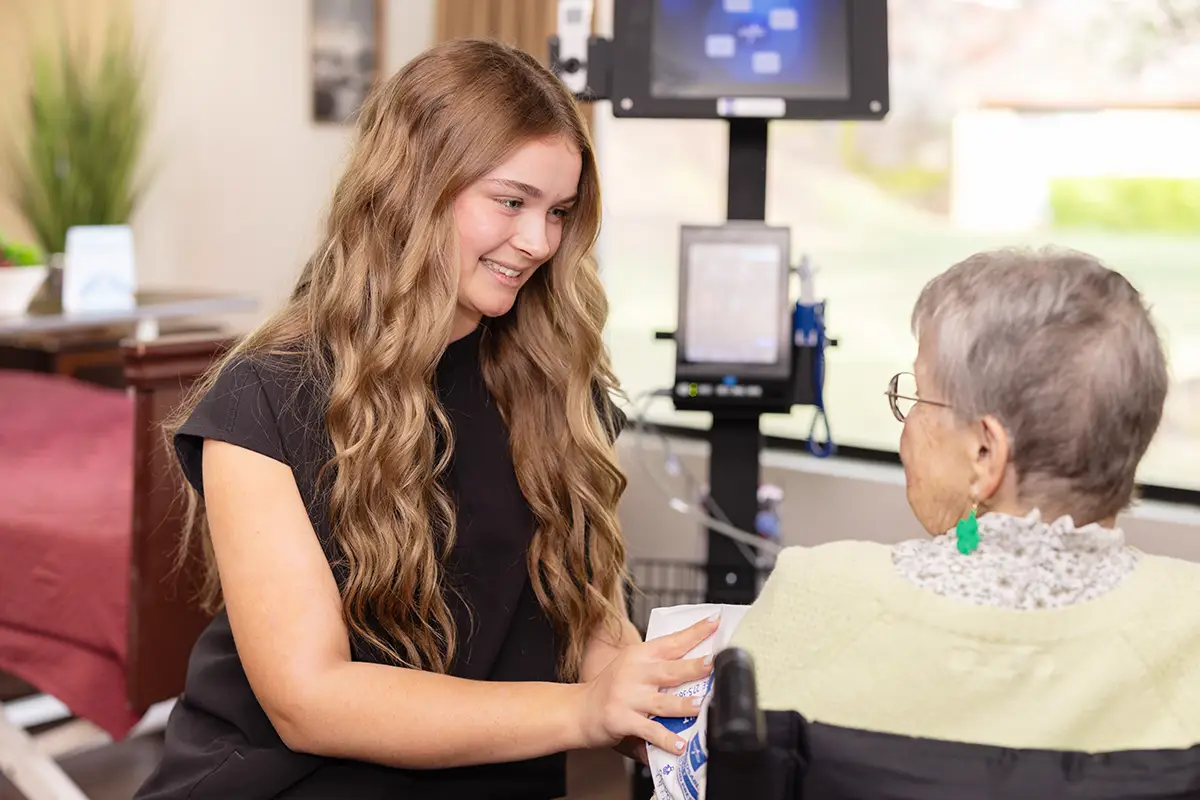 A nurse helping an elderly woman at Oak River